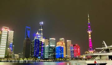 Night view of Shanghai's skyline featuring brightly lit modern skyscrapers.