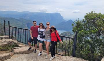 Group of people posing at a viewpoint with a scenic canyon.