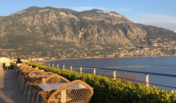 Coastal dining area with stunning mountainous view.