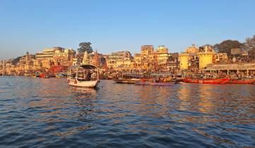 Boats on the Ganges River and colorful buildings.