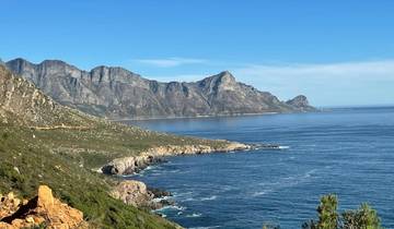 Coastal landscape with mountains and sea under a clear blue sky.