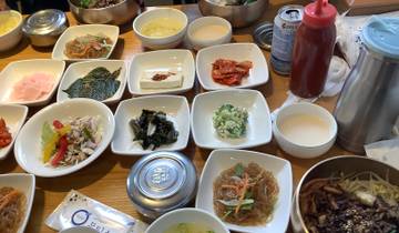 Korean meal with various side dishes on a wooden table.