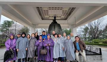 Group of people in front of a large bell.