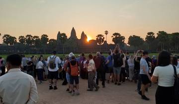 Crowd of people watching sunset over ancient temple