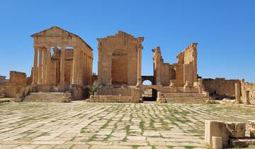 Ancient ruins with columns under a clear blue sky.