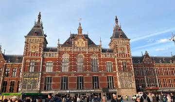 Amsterdam Centraal station from an elevated viewpoint with a busy crowd.