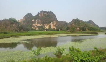 Scenic view of rock formations and a pond with lily pads.