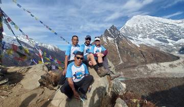 Group of hikers posing with mountain peaks in the background.