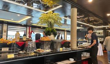 Buffet setup with a man arranging food inside a restaurant.