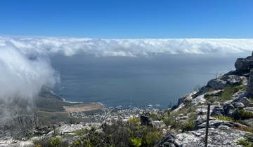 View from a mountain top overlooking clouds and the ocean.