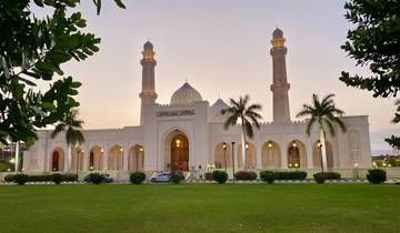 Beautiful mosque with two minarets and a lawn.