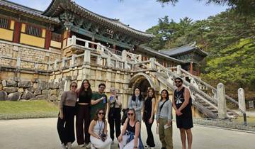 Group posing in front of a traditional Korean temple.