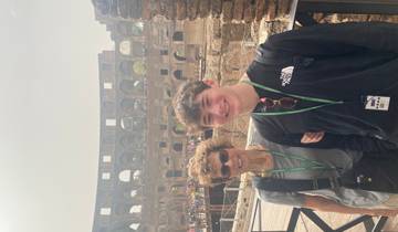 Two people posing in front of the Colosseum.
