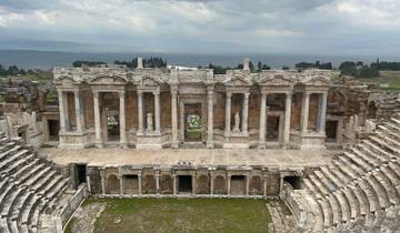 Ancient amphitheater ruins with dramatic sky.