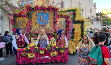 Colorful street festival with people in traditional costumes.