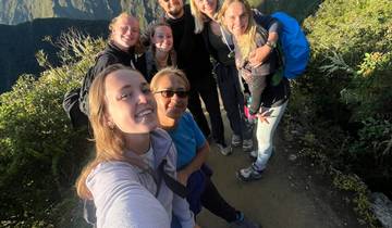 Group selfie on a mountain hike with lush greenery.