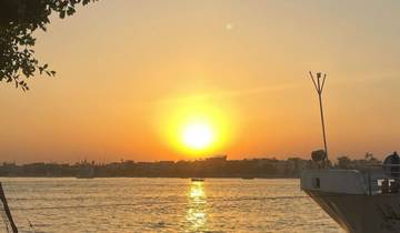 A beautiful sunset over a calm river with a boat in the foreground.