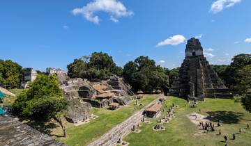 The ancient ruins of Tikal with towering structures and greenery.
