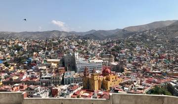 Panoramic view of a colorful city with hills in the background.