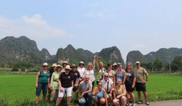 Group posing in a lush green wilderness with mountains.