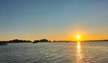 A scenic sunset view over a bay with boats visible in the water.