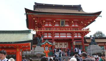 A red traditional Japanese building with visitors.