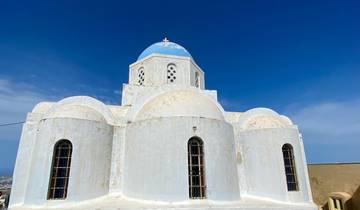 Whitewashed domed church with a blue dome under a clear sky.