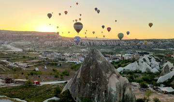 Hot air balloons floating over a landscape at sunrise or sunset.