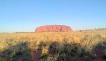 Uluru rock formation in Australia under clear skies.