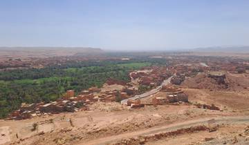 Panoramic view of a sprawling Moroccan town in a desert landscape.