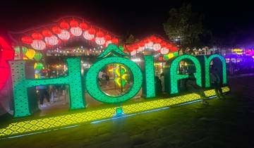 Colorful sign of Hoi An with lanterns at night.