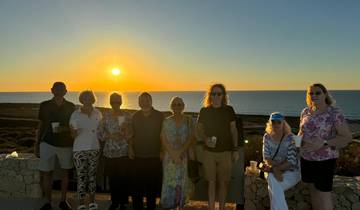 Group posing at sunset near the ocean.