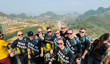 A group of people posing with a mountain landscape in the background.