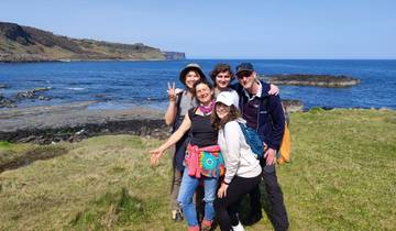 Group of people posing near a scenic coastal landscape.
