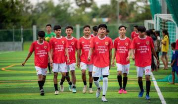 Soccer team walking on a field with red jerseys.