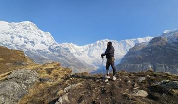 Solitary hiker gazing at mountain peaks.