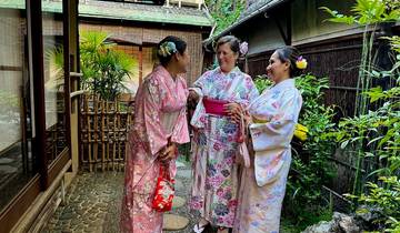 Three women dressed in traditional garments talking outside.