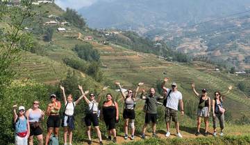 Group of hikers posing in front of terraced hills.