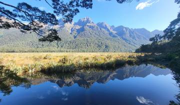 A mountain range reflected in a calm body of water.