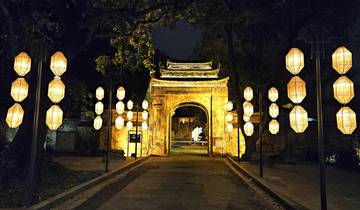 Illuminated entrance with hanging lanterns at night.