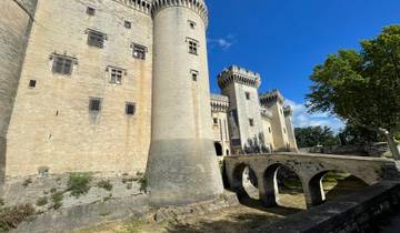 Large stone castle with towers and an arched bridge.