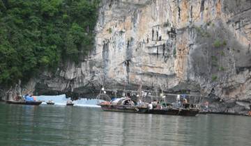 Boats in a picturesque bay with limestone cliffs.