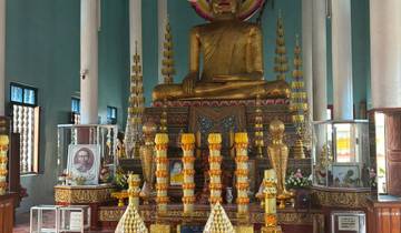 A seated golden Buddha statue inside a temple.