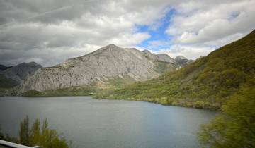 Mountain range with a lake and lush greenery.