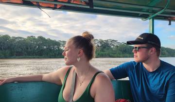 Two people on a boat enjoying a river view.