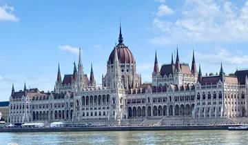 Elegant building with spires by a river.