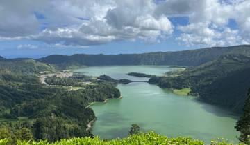Lush green landscape with a lake and mountains.