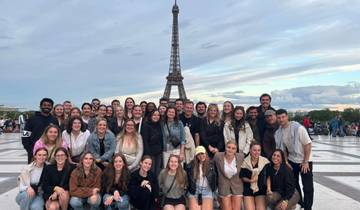 Large group photo in front of the Eiffel Tower in Paris.