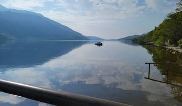 Calm lake with reflections of mountains and sky.