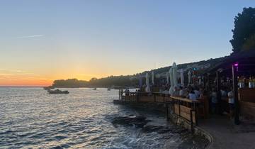 A scenic view of the sea with a setting sun in the background.